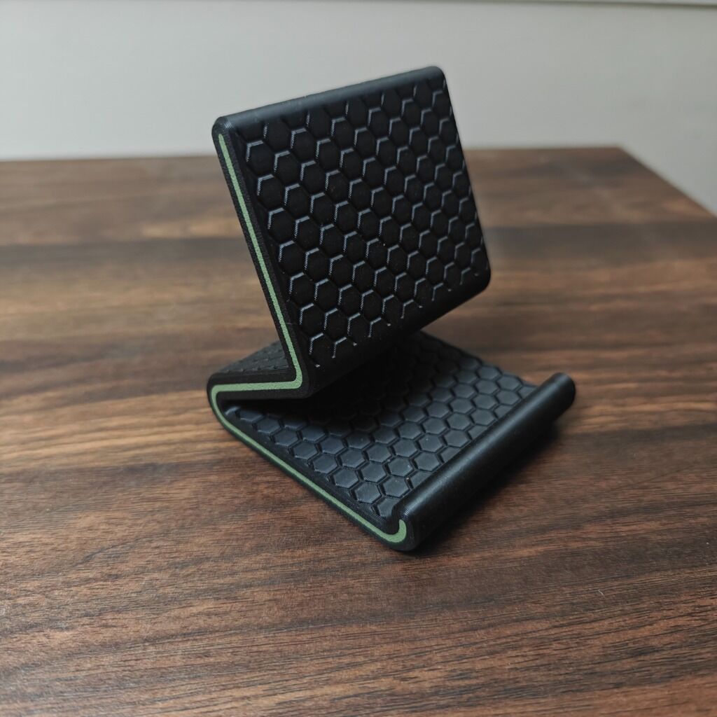 3D printed hexagonal pattern phone stand in black with green accent